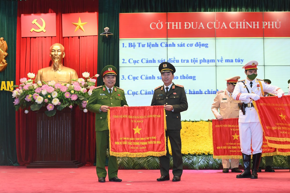 Đồng chí Thượng tướng Trần Quốc Tỏ, Thứ trưởng Bộ Công an, thừa ủy quyền của Chủ tịch nước trao tặng Cờ thi đua của Chính Phủ cho Cục Cảnh sát QLHC về TTXH